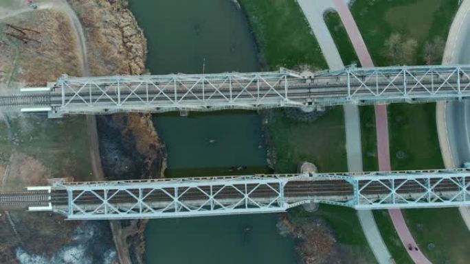 跨河金属铁路轨道桥，空中俯视图。低头看高速铁路列车线。横跨狭窄河流的空铁路