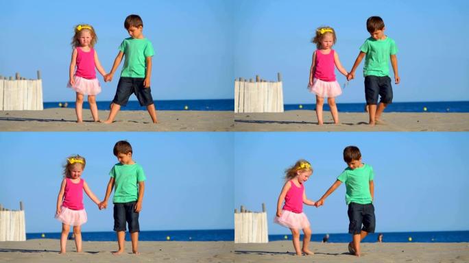 穿着粉红色裙子的小男孩和女孩站在沙滩上扔沙子