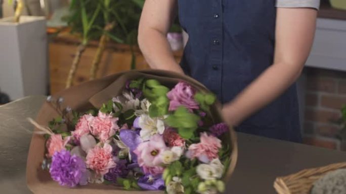 花店女人做一束美丽的花。花卉艺术概念。商店里的职业女孩。专业花店在花店制作花束。女商人小企业主。