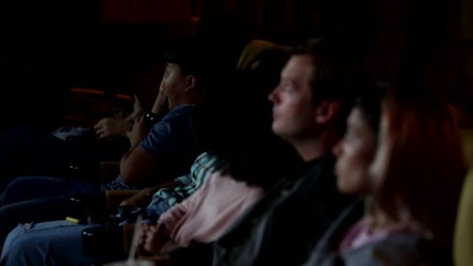人们和家人一起坐在电影院看电影，幸福