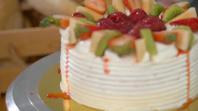 瓦尼拉蛋糕覆盖黄油奶油，装饰有草莓和猕猴桃切片