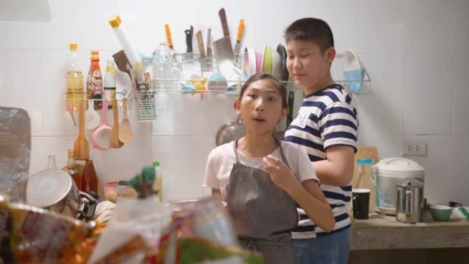 亚洲女孩和她的兄弟在家帮助自己烹饪煎蛋卷和食物。