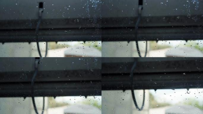 水泡从汽车挡风玻璃上流下，经过彻底清洗，用刷子和肥皂清除脏物。汽车维修站的车辆清洗