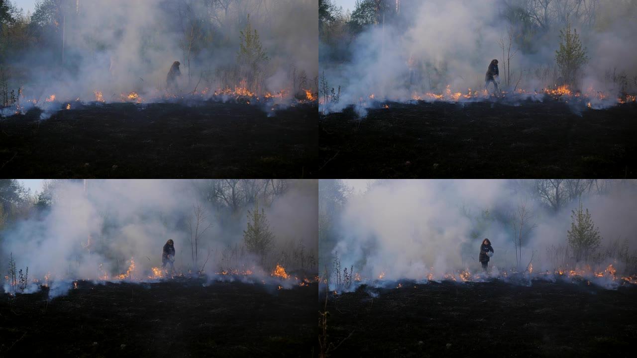 妇女试图通过从塑料瓶中倒水来阻止森林即将发生的大火。