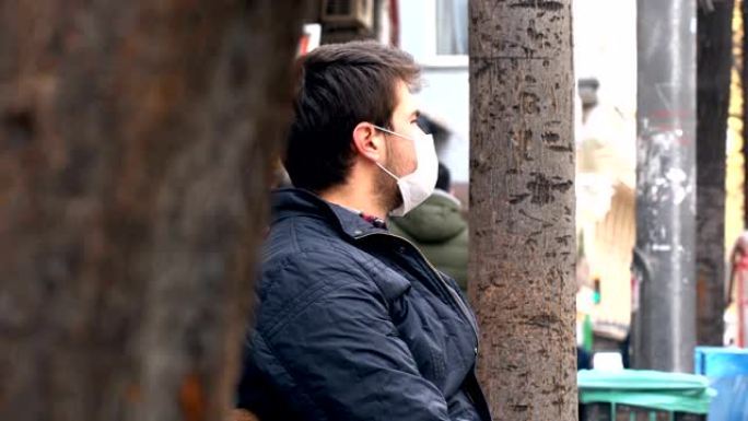 男人戴着口罩在公共区域四处张望。冠状病毒症状。