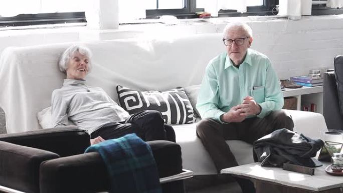 退休和热爱它-老年人坐在他们的客厅和聊天随意