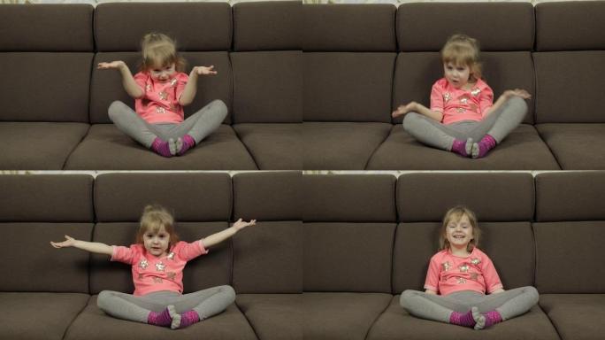 积极的女孩在家里的沙发上穿着粉红色的衬衫在情感上做鬼脸和微笑