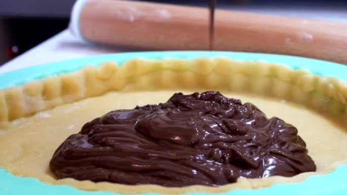 将巧克力釉倒在酥皮糕点上，做馅饼