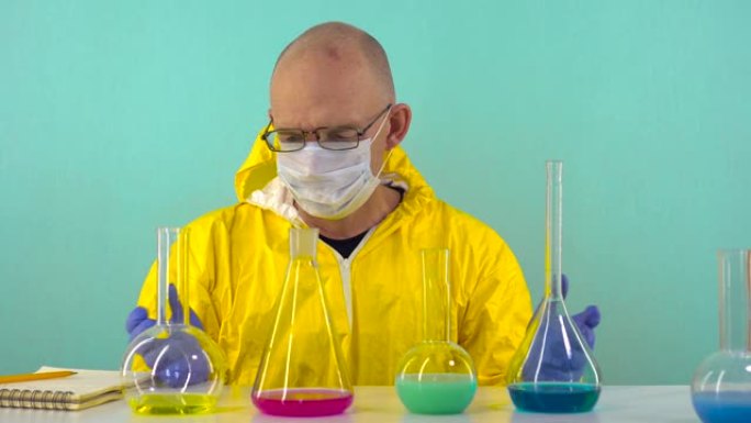 一名化学实验室助理穿着黄色防护服，戴着手套和眼镜，在他面前拿着试剂的烧瓶，他耸了耸肩，不知道从哪里开