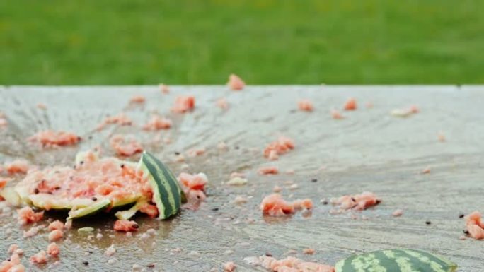 成熟的西瓜掉到地板上，碎成碎片。喷雾向四面八方飞行。慢动作180 fps视频
