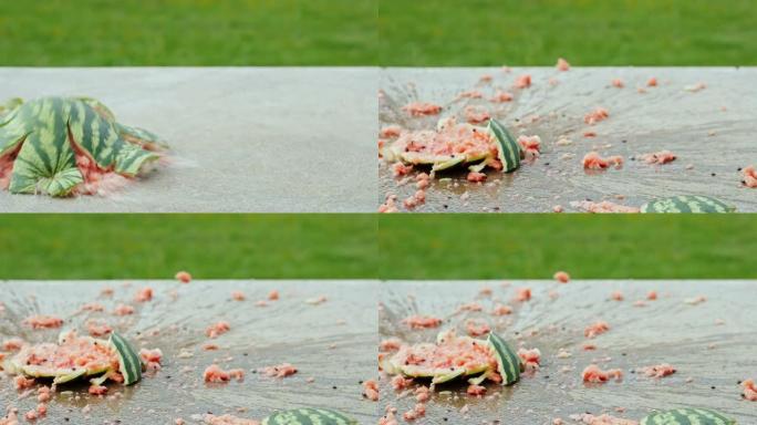 成熟的西瓜掉到地板上，碎成碎片。喷雾向四面八方飞行。慢动作180 fps视频