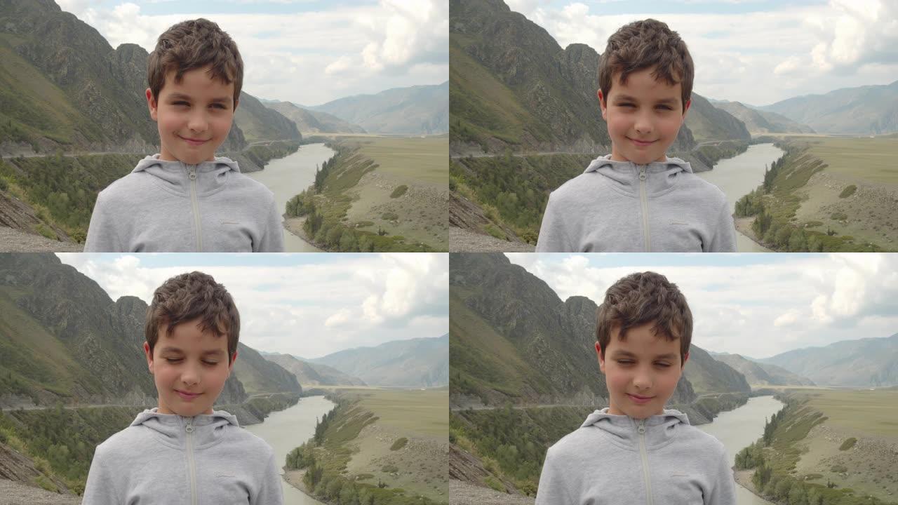 俄罗斯阿尔泰山区风景上微笑的小男孩肖像