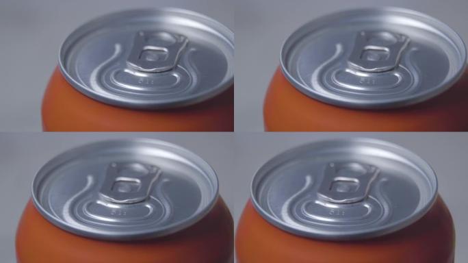 封闭橙色罐头顶部的特写镜头。含碳酸软饮料或酒精的金属容器。饮料，液体