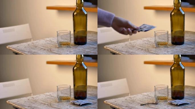 用粉红色修指甲的女性手将一块钱和钥匙放在桌子上靠近一杯威士忌和瓶子，酒精成瘾的概念