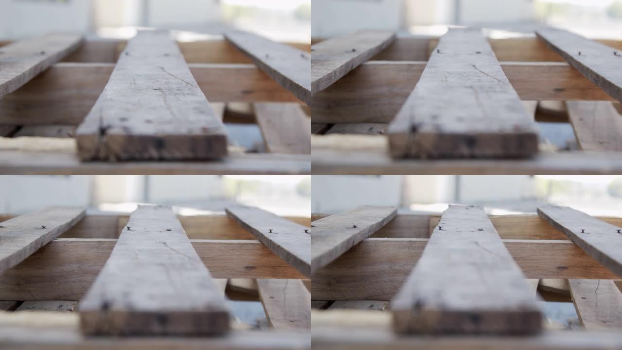 慢动作艺术近景拍摄的人造木松托盘在户外仓库装载码头散装重货物航运或DIY的家庭制作的艺术项目