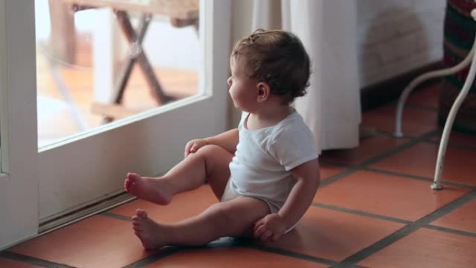 可爱的婴儿想离开家，蹒跚学步的孩子靠在窗户上，婴儿想出去