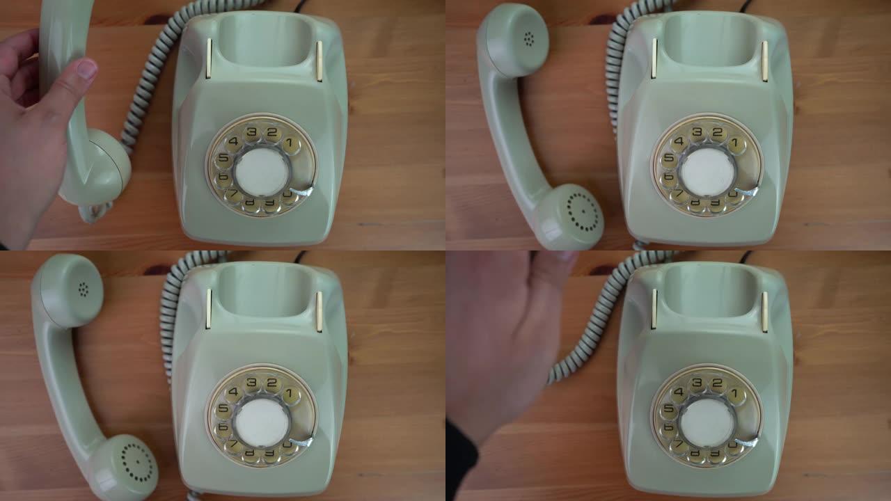 一只手拿起古董手机，将听筒放在桌子上。