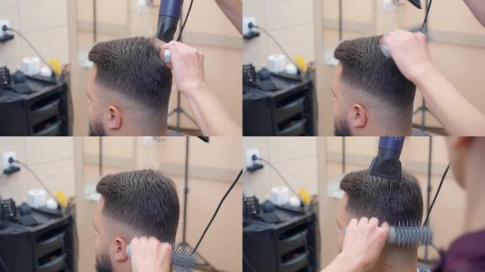 美发沙龙中的男性，近距离拍摄。造型师用圆梳子和烘干机制作现代发型。理发店内部。