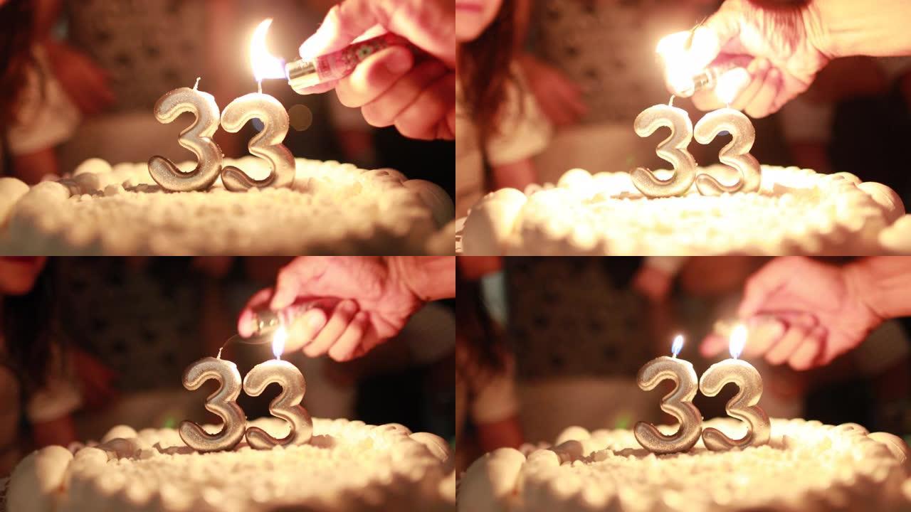 手持照明生日蛋糕蜡烛特写镜头，打火机庆祝33岁