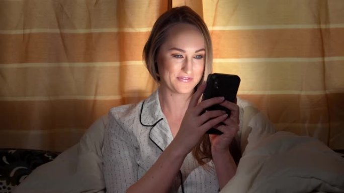 女人在沙发上检疫时用智能手机发短信