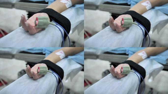病人手指上的脉搏血氧计。手术期间安装在患者手上的外周静脉导管(PVC)。慢动作