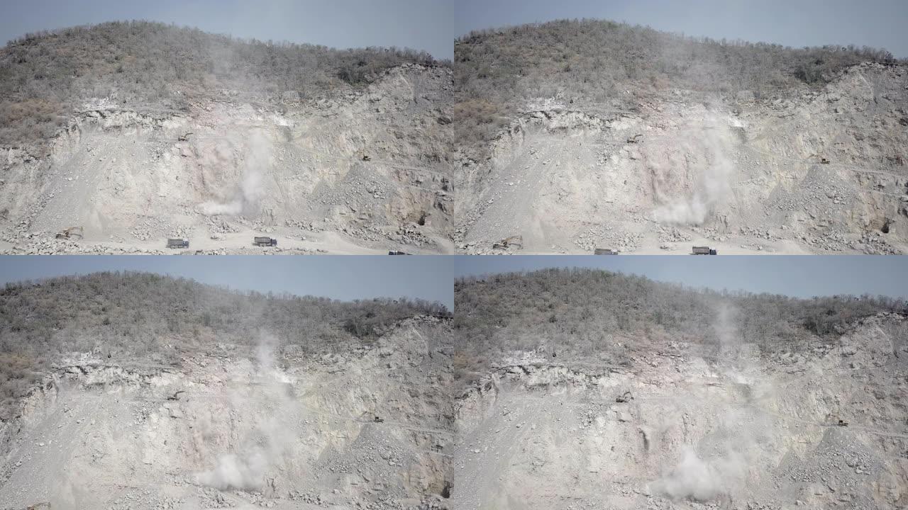 当自卸车在采石场工作时，飞向挖掘机，从山上挖出破碎的岩石