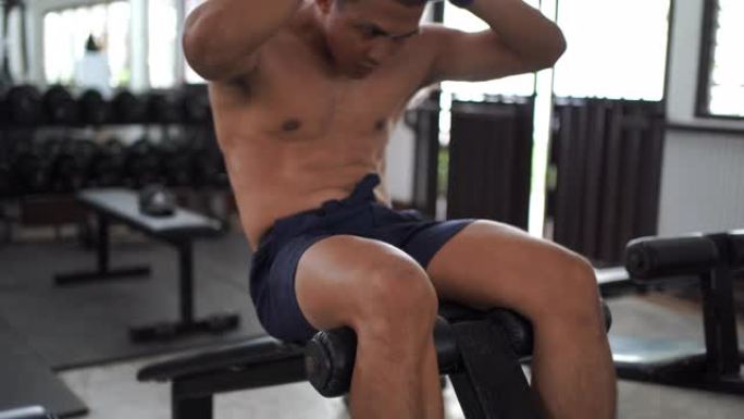 亚洲男模正在健身房锻炼。