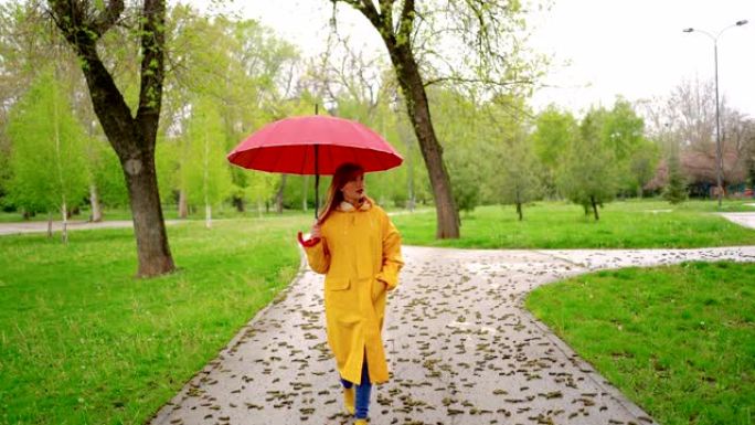 下雨天在公园散步的年轻女子