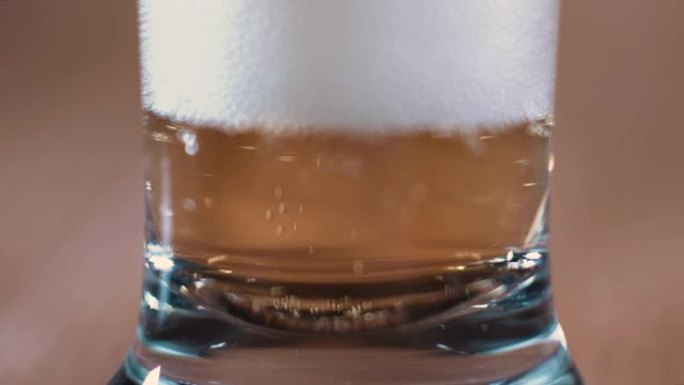 一杯和一杯美味的啤酒站在棕色背景上。美丽的灯光点燃的芬芳啤酒刺激食欲。