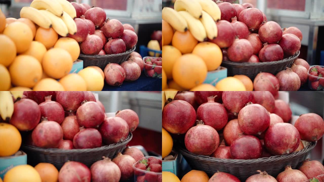 当地农贸市场上的一系列新鲜异国水果。在市场柜台展示甜橙，香蕉，草莓和石榴。丰富多彩的成熟水果，富含维