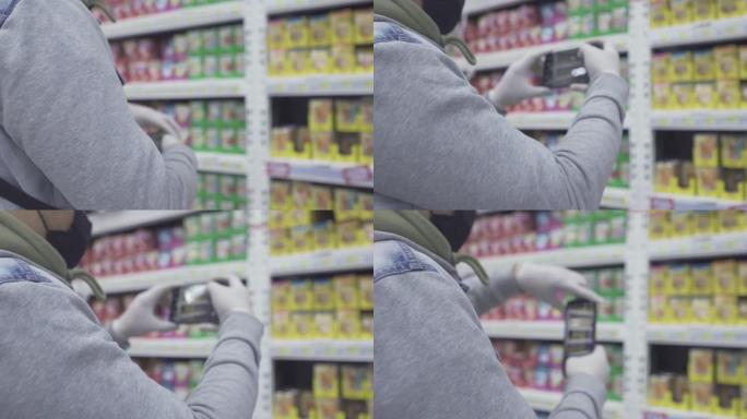 男子使用智能手机在购物中心为产品价格标签拍照