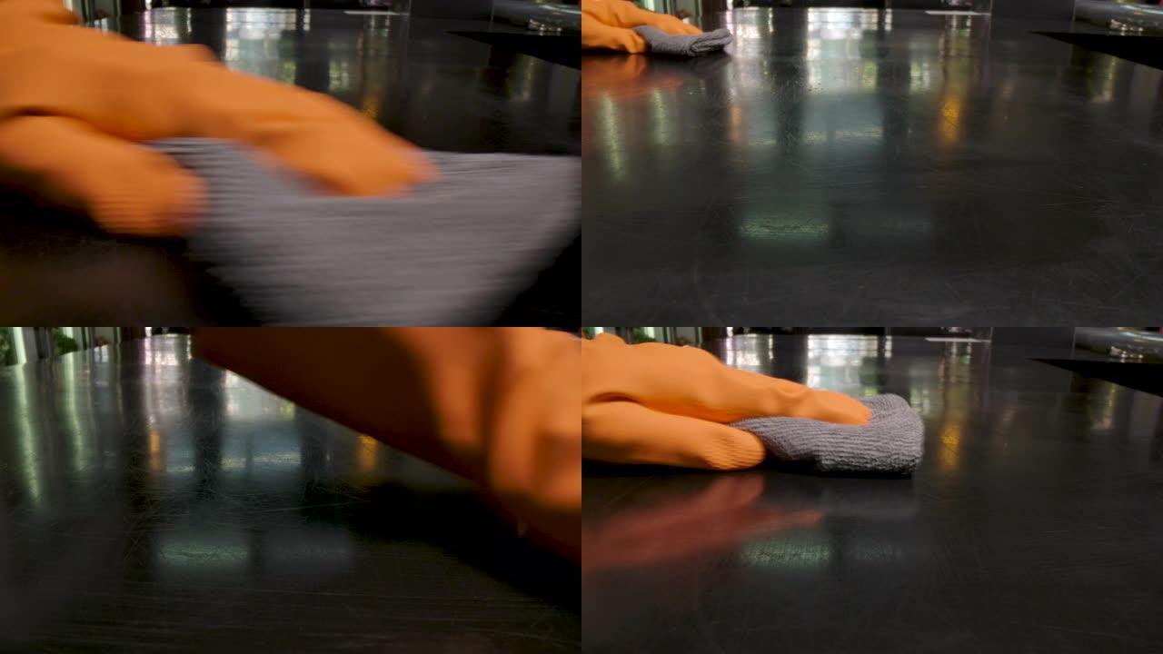 戴着橙色手套的手清洁桌子Covid病毒意识