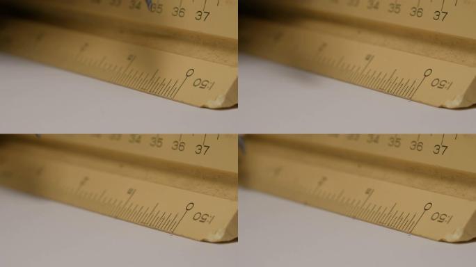 特写使用三角形标尺，用铅笔在白纸上绘制建筑图纸，模型。规模1:50。
