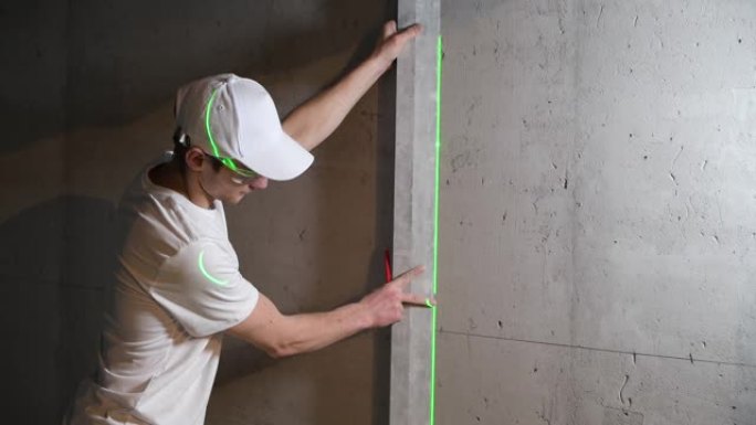 大师将规则应用于墙壁，检查激光水平仪，应用标记