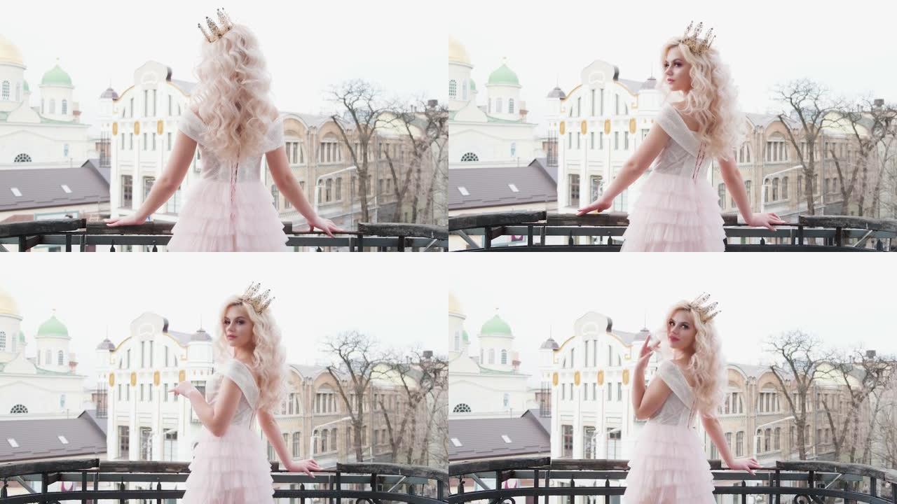 美丽的年轻性感女人站在阳台上，摆姿势背景冬春老城市景观。金发公主可爱的脸优雅的连衣裙。健康白色长卷卷