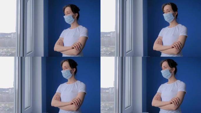 慢动作: 戴着医用口罩并向窗外看的沉思妇女