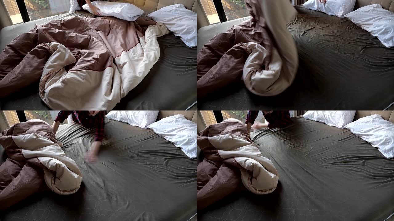穿着衬衫的年轻女孩用棕色毯子盖住大床，并在白色枕头附近固定