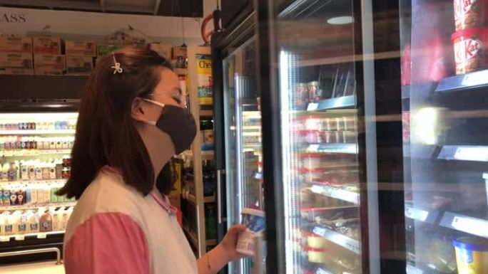 亚洲少女在超市购物，戴口罩