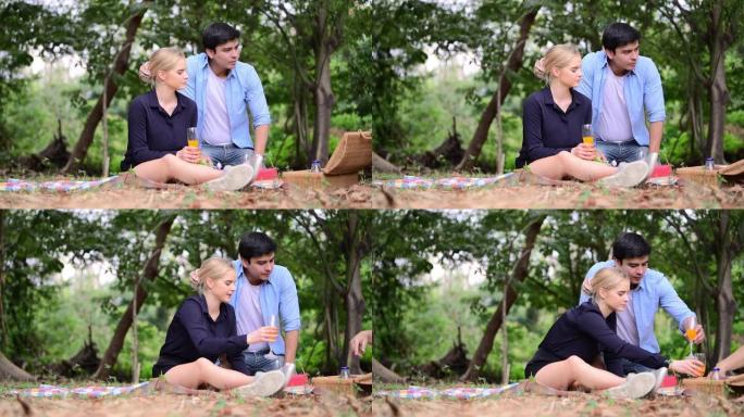 坐在野餐时，男友在公园送礼物使女友感到惊讶。