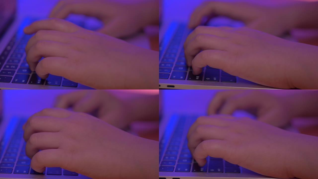 用手打字笔记本电脑与led紫色光背景。