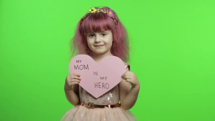 女童公主抱着粉红色的纸心，上面有关于母亲的文字。母亲节
