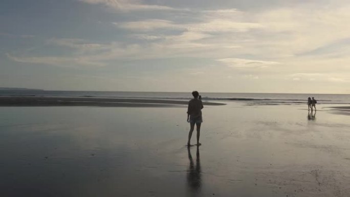 年轻女子在海滩散步的鸟瞰图