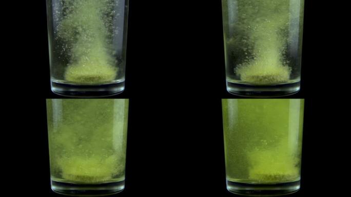 将维生素c片剂倒入装有水的透明玻璃杯中。泡腾黄色药片溶解。黑色背景上的玻璃。慢动作。特写