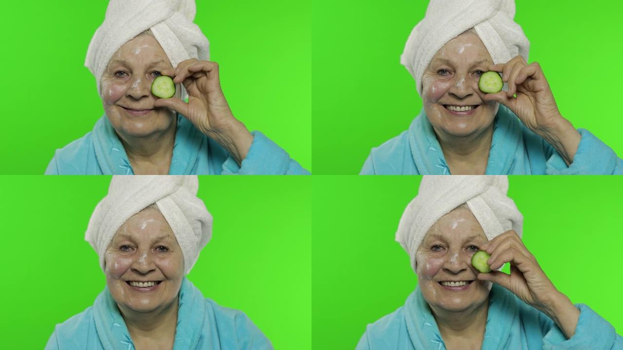 穿着浴袍的老奶奶。带黄瓜片的老妇人