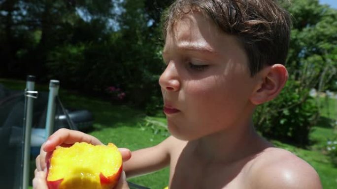 小男孩在户外吃桃子水果