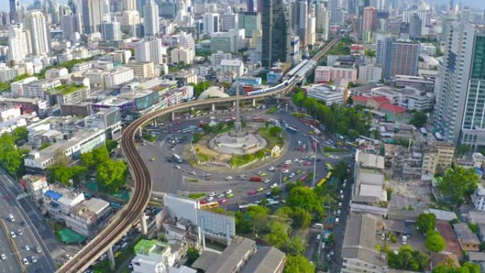 繁忙街道路上胜利纪念碑的鸟瞰图。曼谷市中心天际线的环形交叉路口。泰国。智慧城市金融区中心。日落时的摩