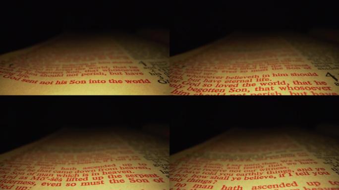 极端微距特写移动滑块拍摄的圣经突出耶稣的话约翰福音3:16在基督教圣经国王詹姆斯翻译与红色字母的话语