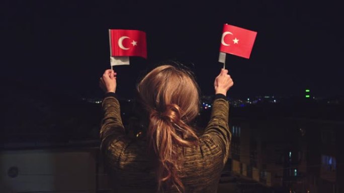 土耳其妇女手持，晚上挥舞着两面土耳其国旗庆祝4月23日儿童节