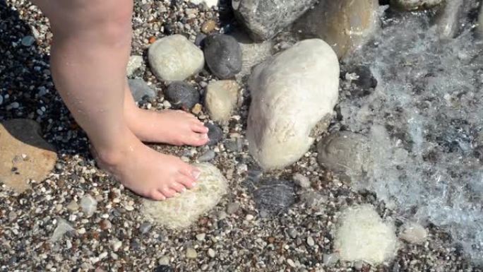 石滩和一对女人的脚被海浪冲刷