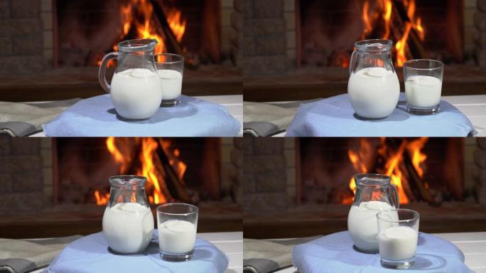 带玻璃壶和带牛奶的玻璃的桌子在舒适的壁炉前旋转，在乡村别墅中，寒假。